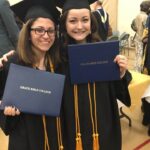 Two girls with diplomas at graduation