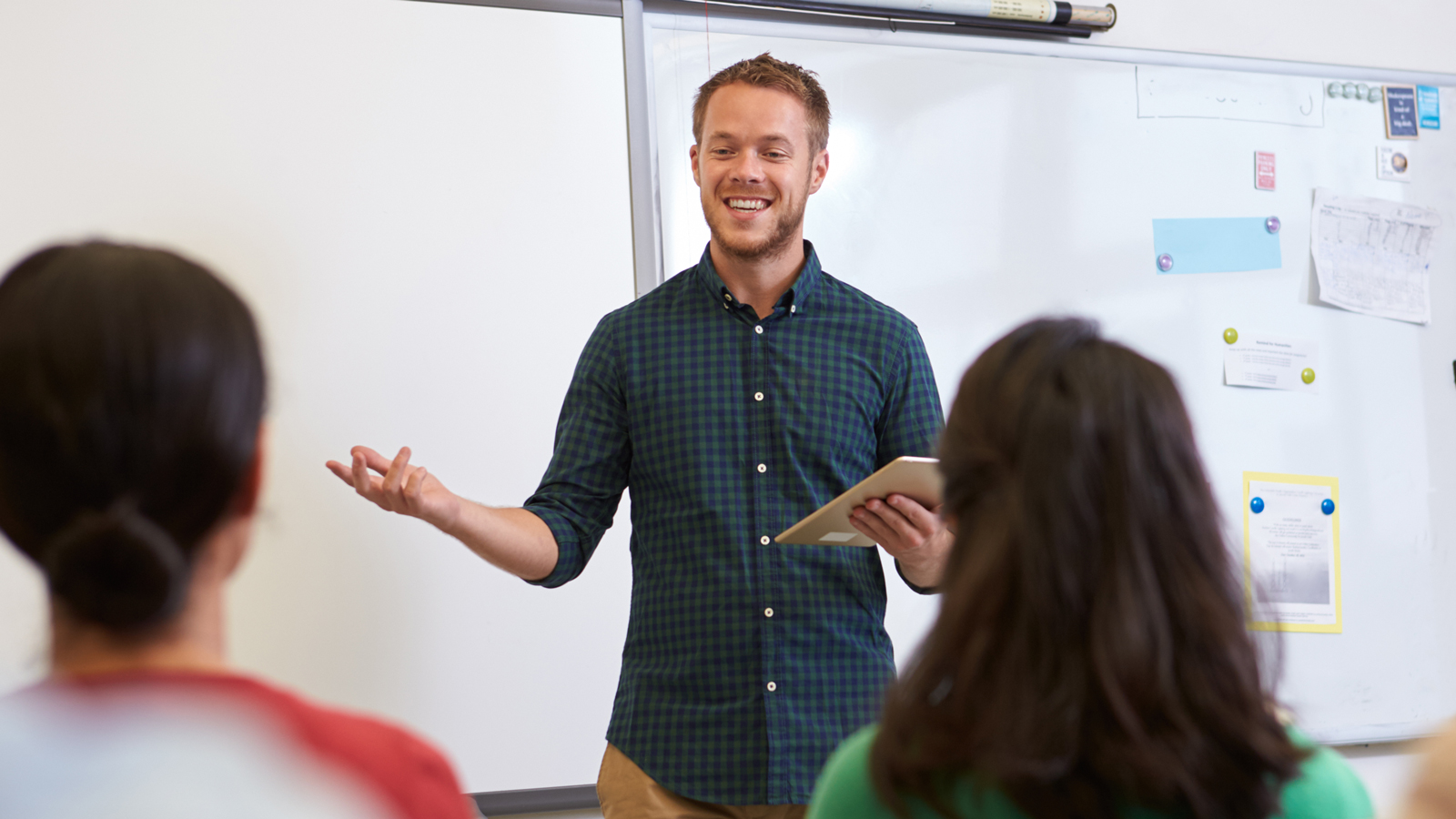 A man standing in front of a group of people in a classroom