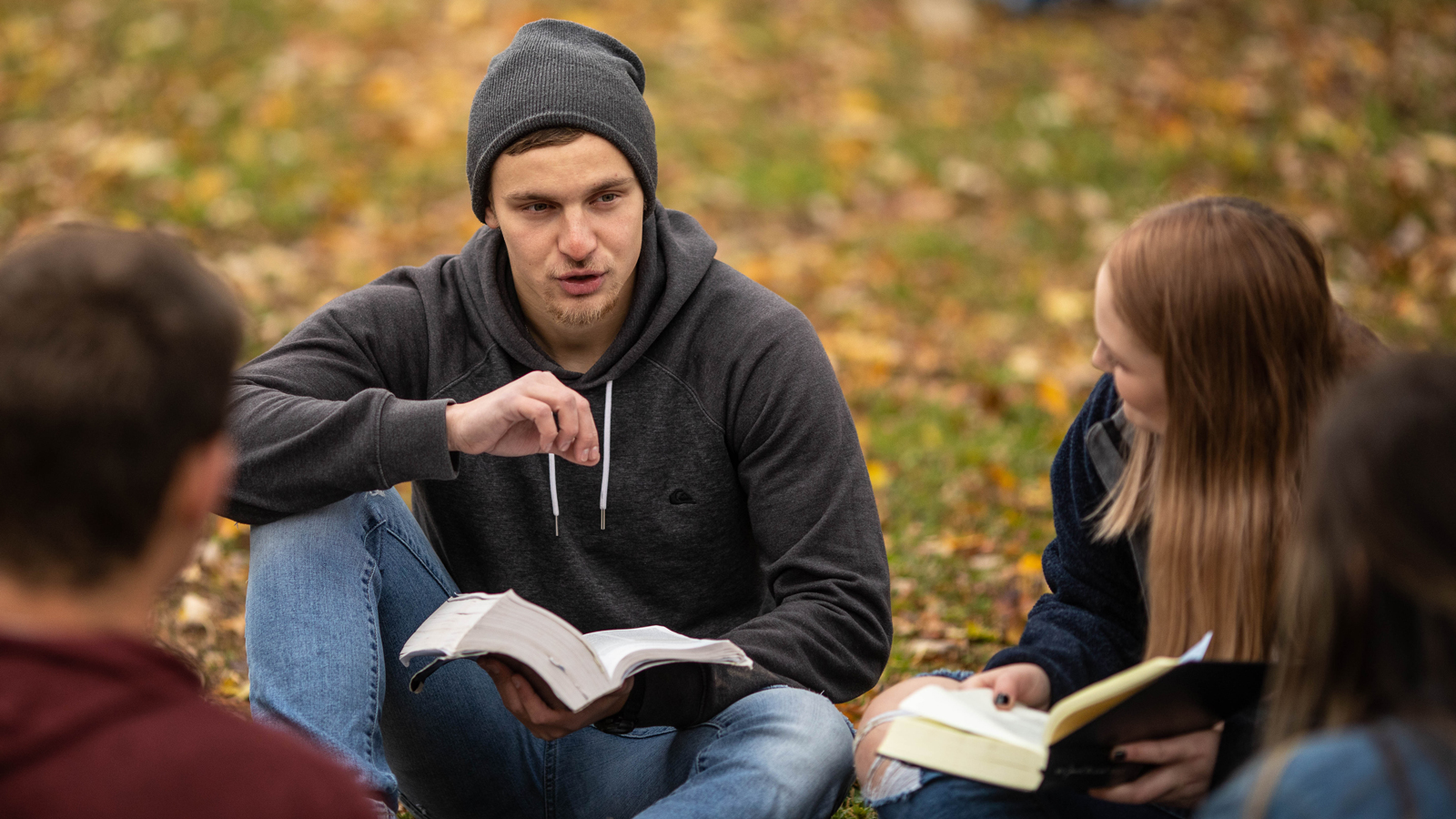 A group of students reading and discussing the Bible