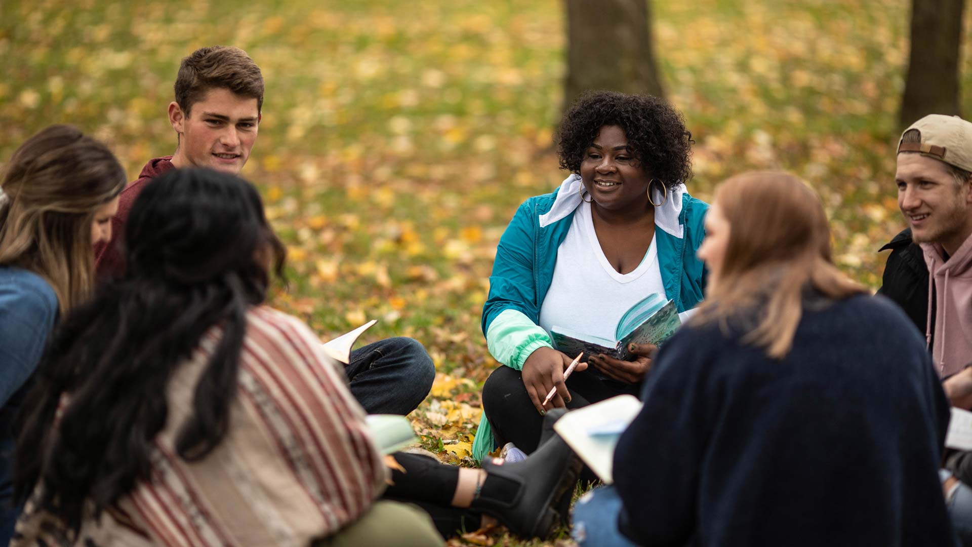 A group of students reading and discussing the Bible