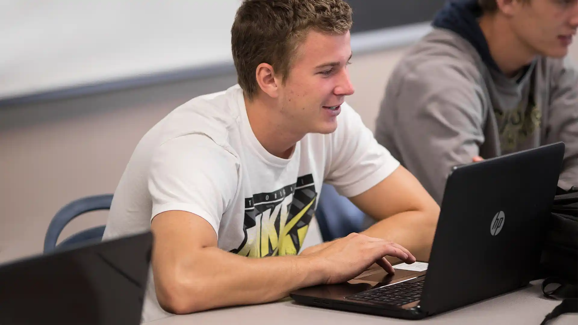 Grace Students in a classroom with a laptop