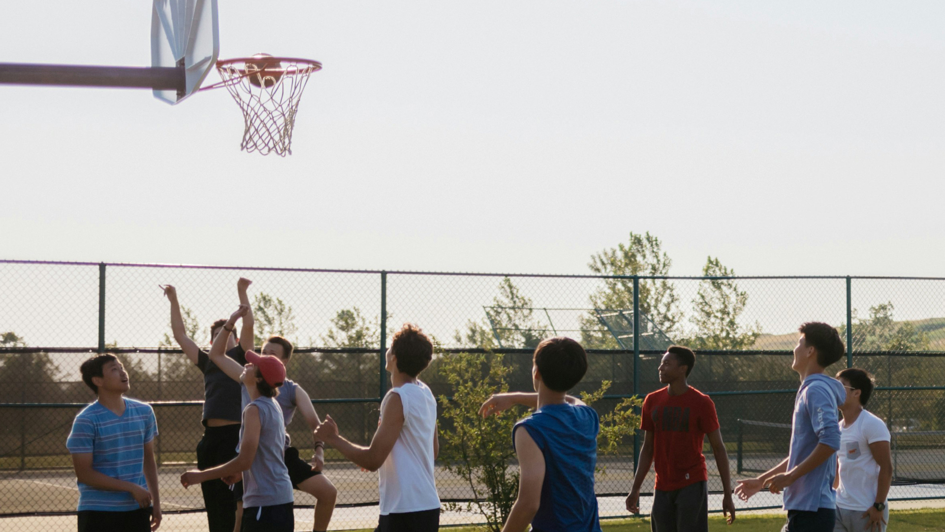 Grace students playing basketball on the outdoor court.