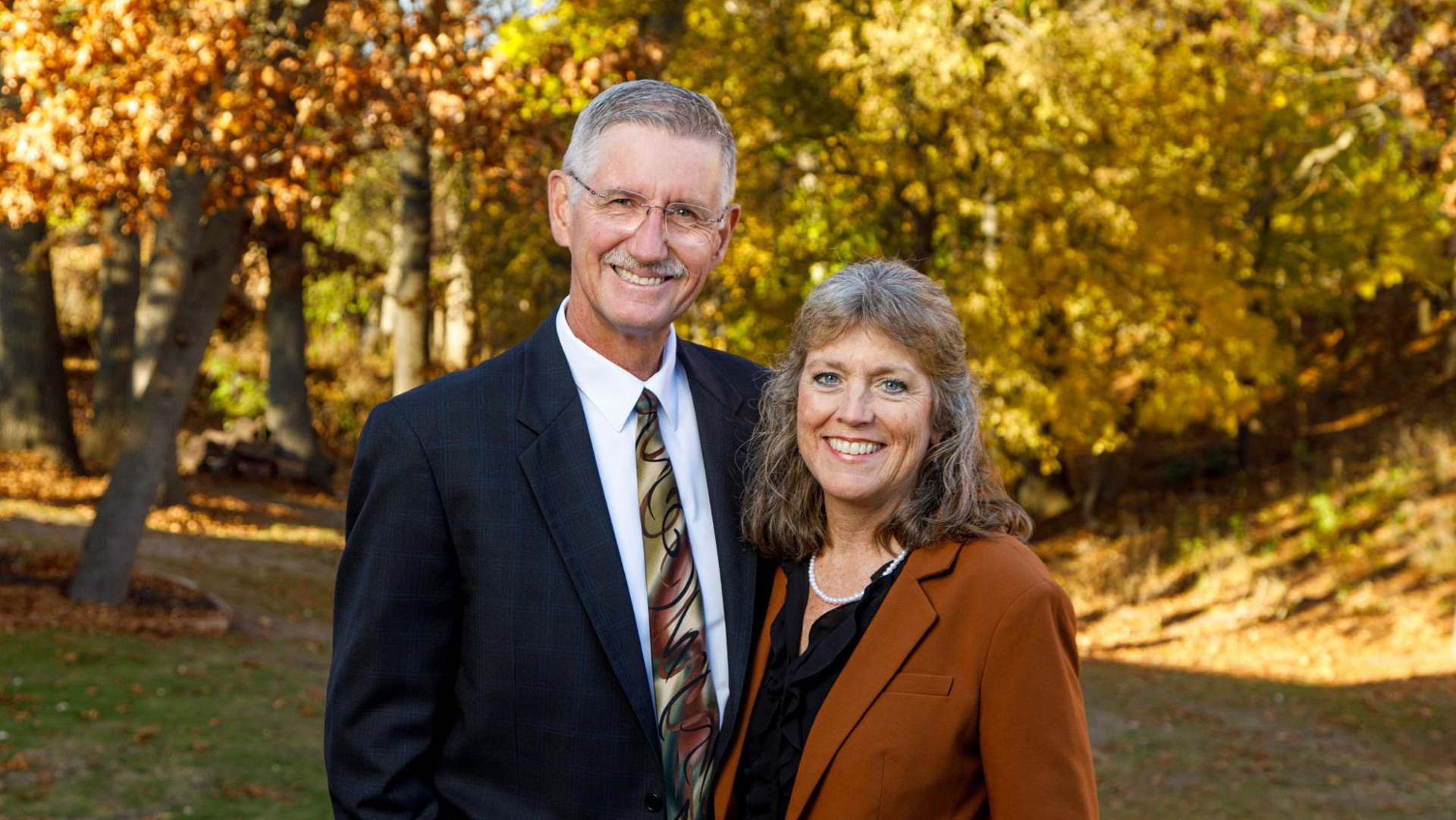 President Ken and Kathy Kemper on the grounds of Grace Christian University in fall.