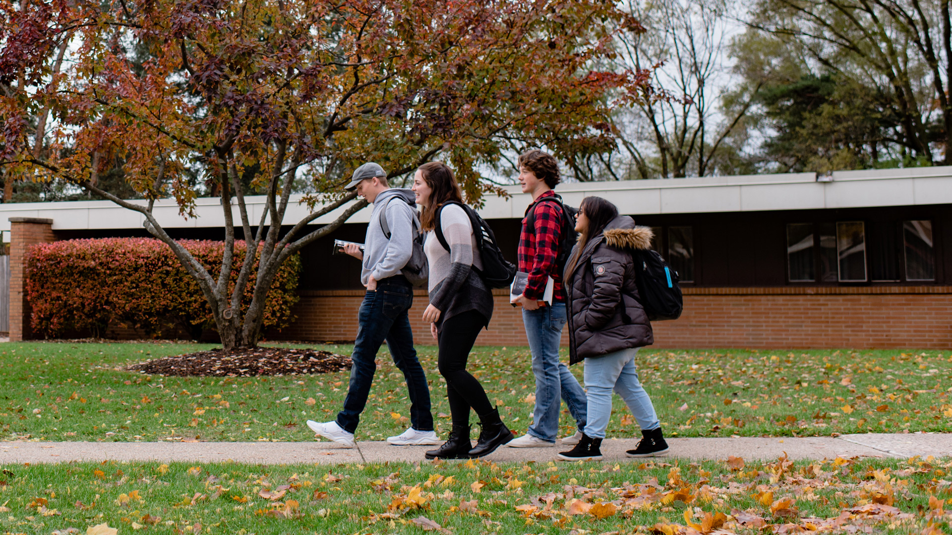 A group of students walking around the Grace Campus.