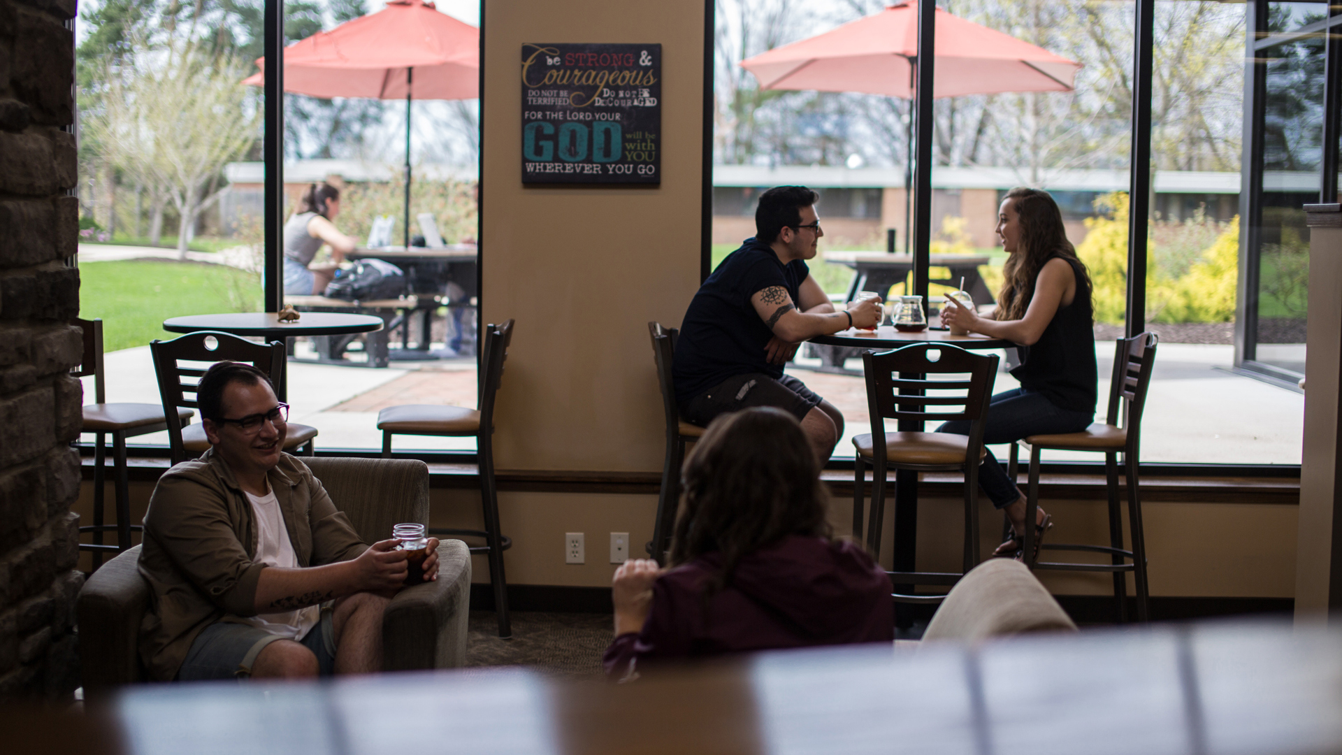 Grace students sitting around tables in the student Commons.