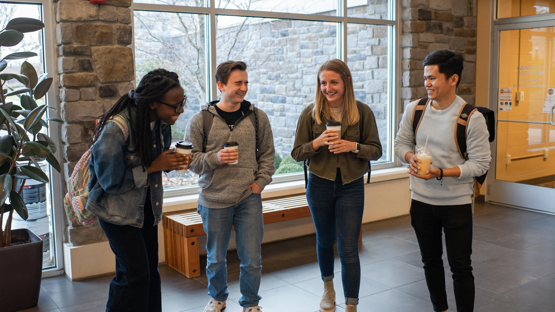 A diverse group of Grace students laughing and talking in the Commons.