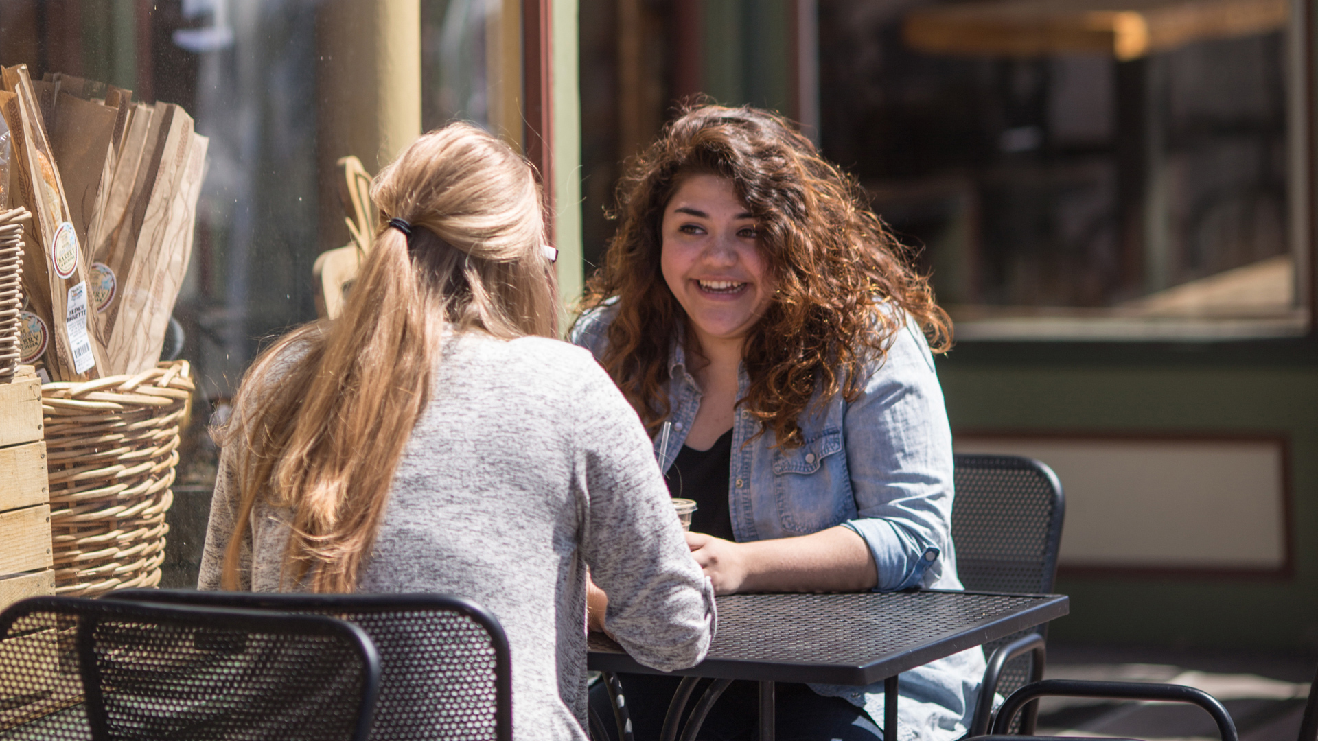 Two Grace students talking over coffee at a coffee shop as part of a Mentorship Program.