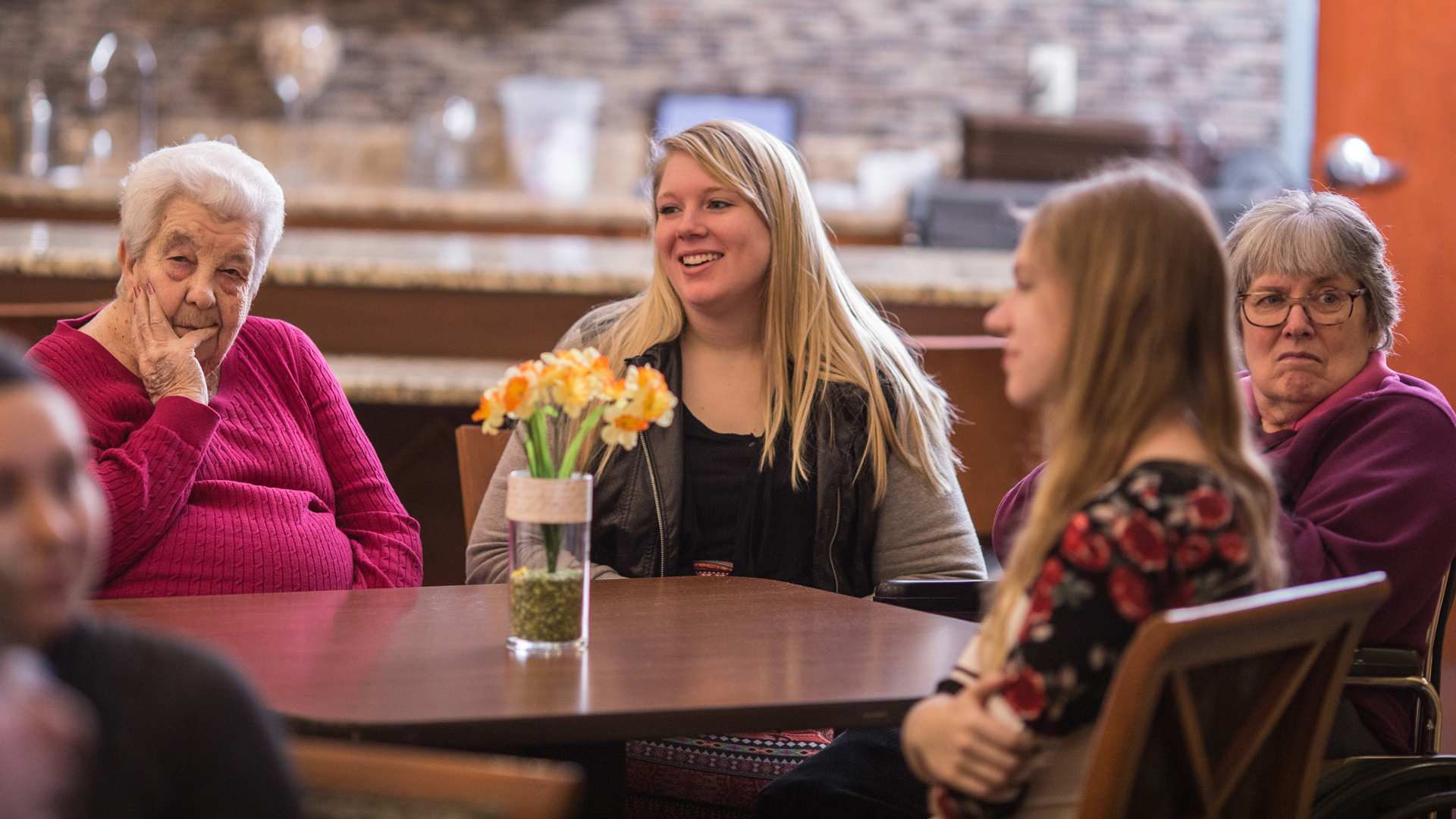 Grace students sitting around a dining table, interacting with members of the Wyoming community.