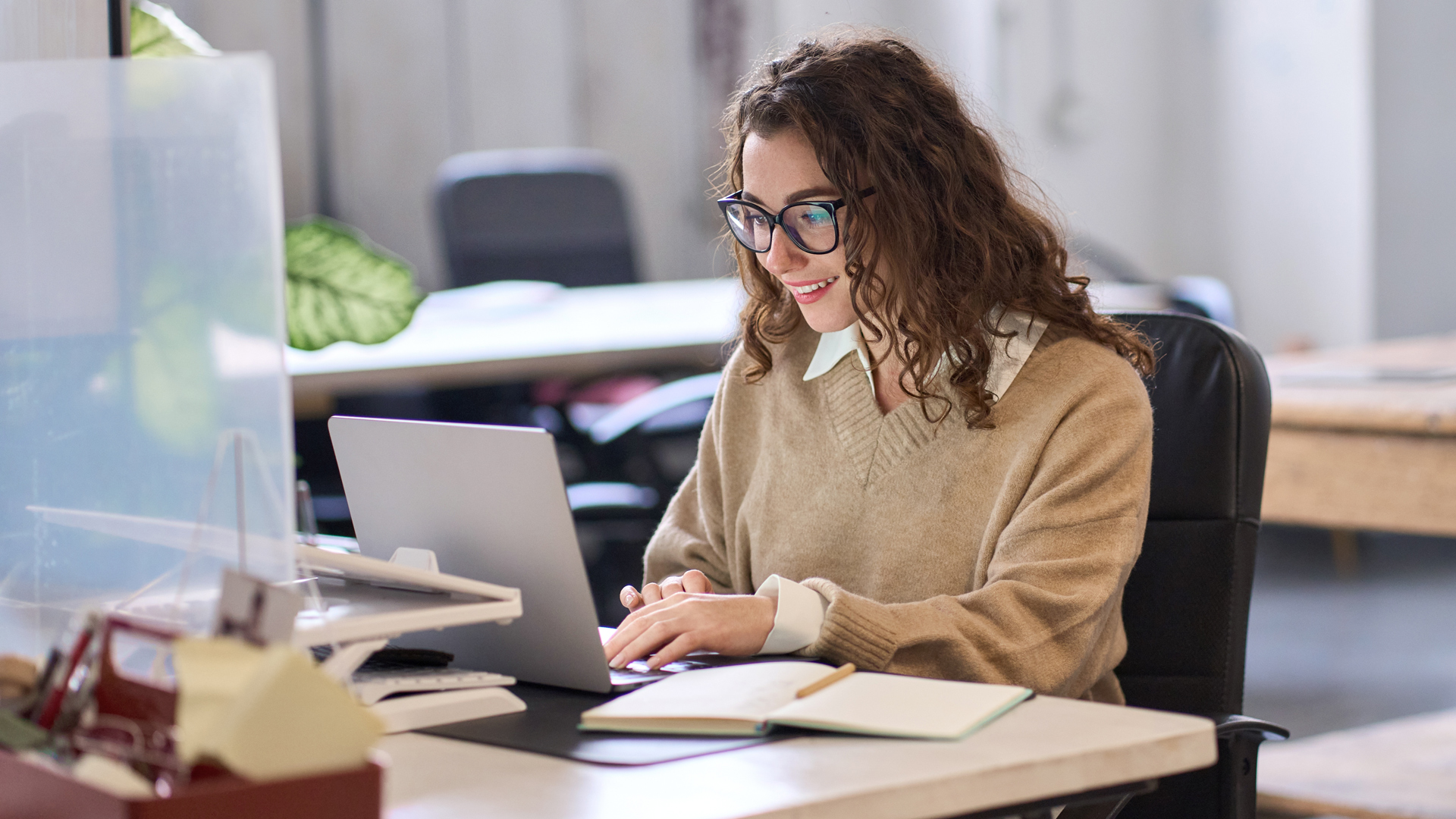 A young businesswoman working at a laptop in an office