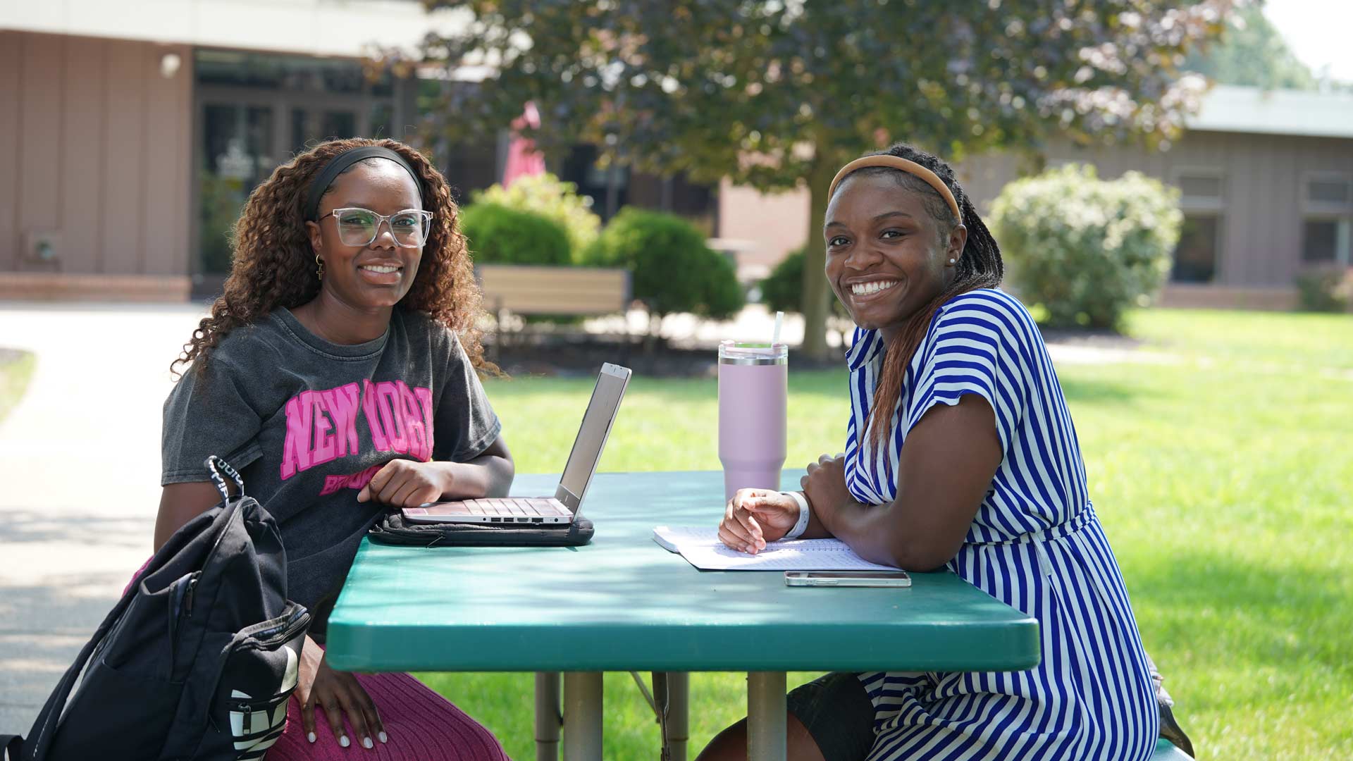 A couple of Grace students studying at an outdoor bench