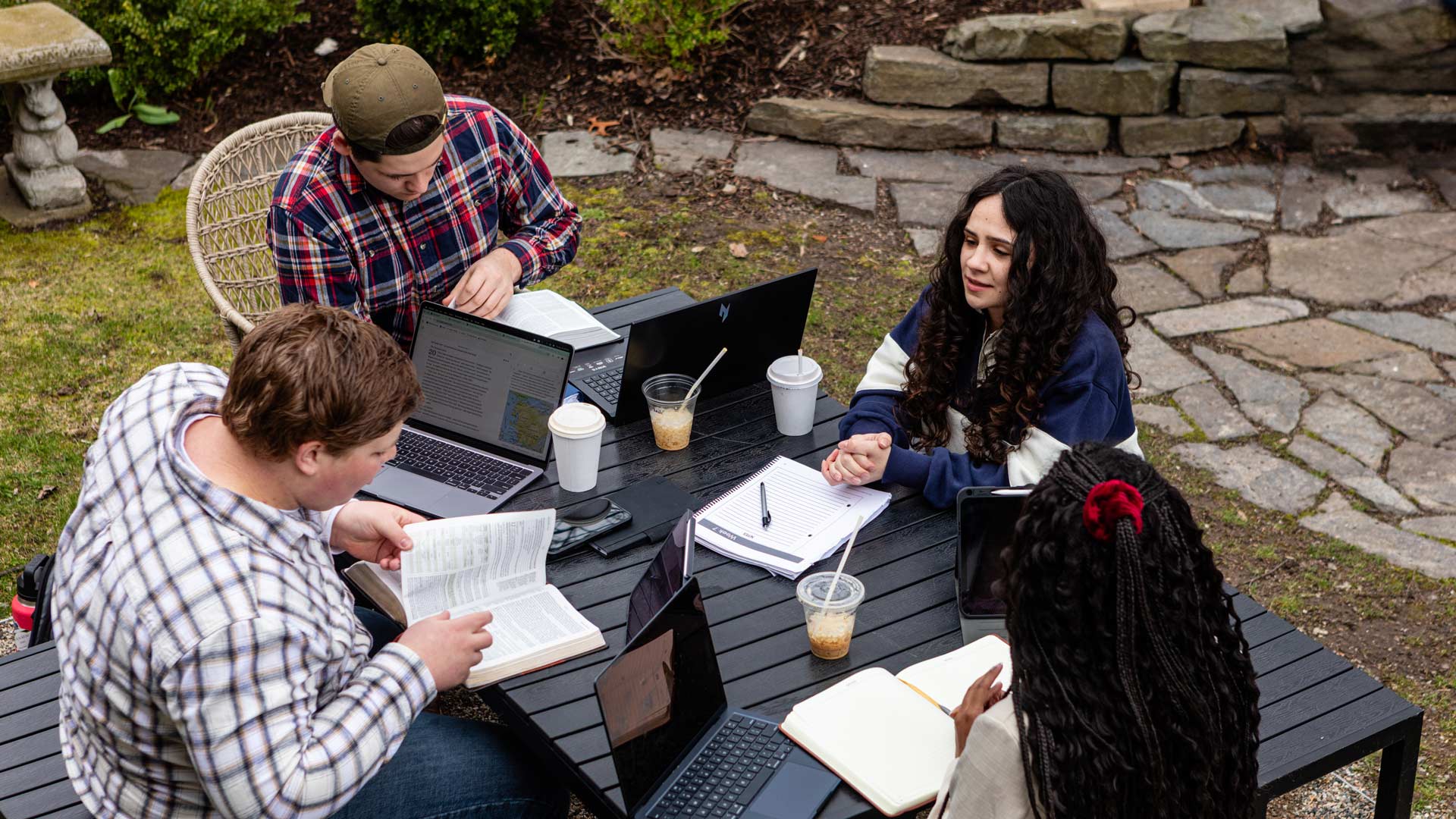 A group of Grace students studying at a outdoor table.
