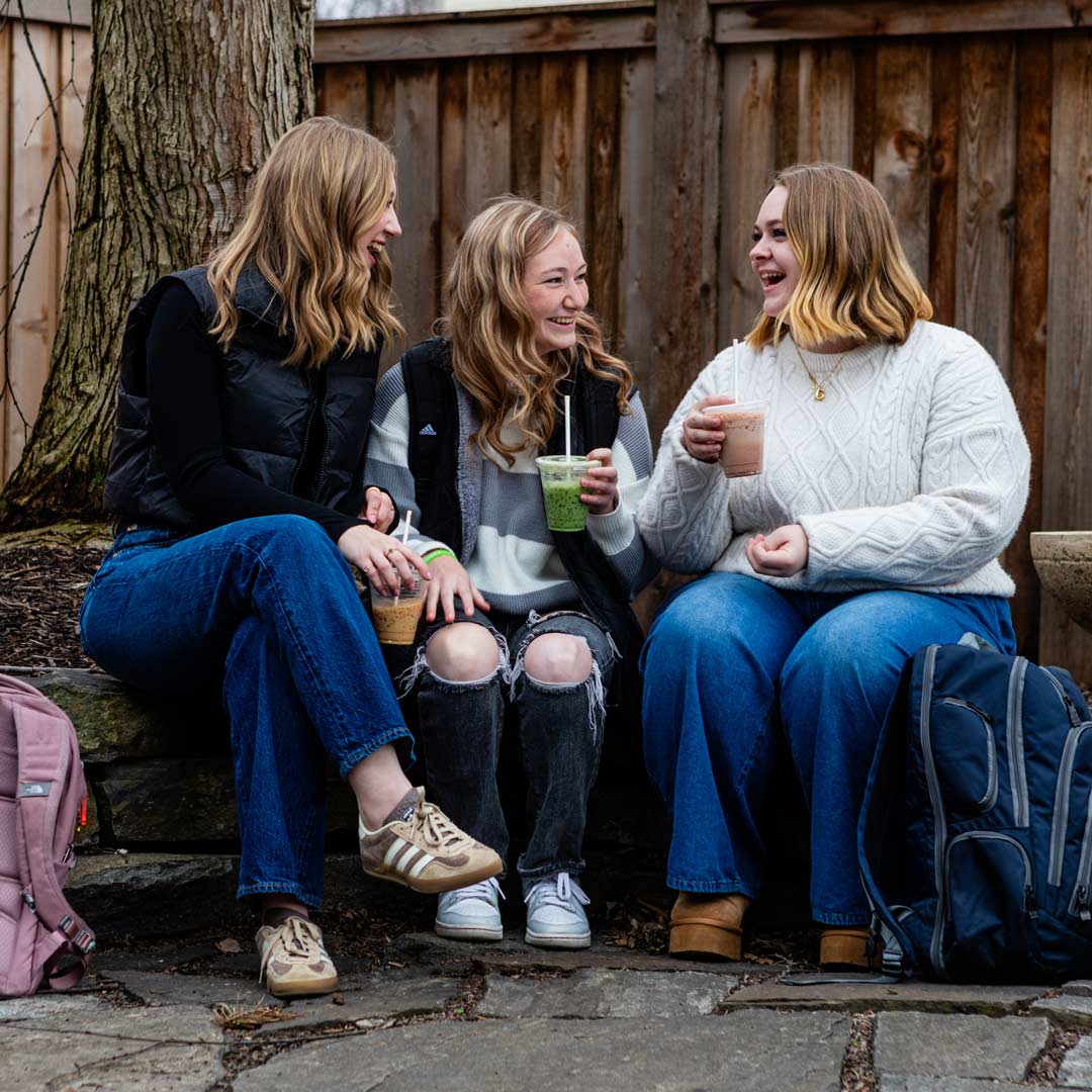 Happy Grace students sitting in a group outside